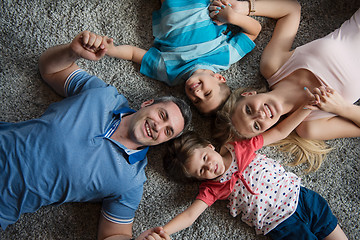 Image showing happy family lying on the floor