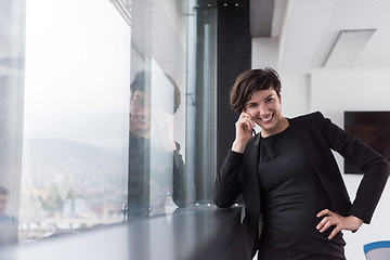 Image showing Elegant Woman Using Mobile Phone by window in office building