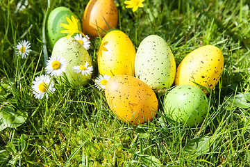 Image showing colored Easter eggs hidden in flowers and grass