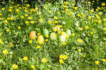 Image showing colored Easter eggs hidden in flowers and grass