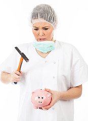 Image showing a woman doctor breaks his piggy bank with a hammer