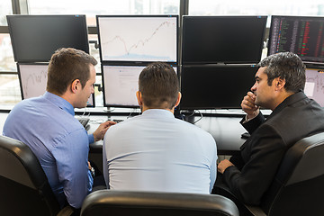 Image showing Business team brainstorming while checking data at computer screens.