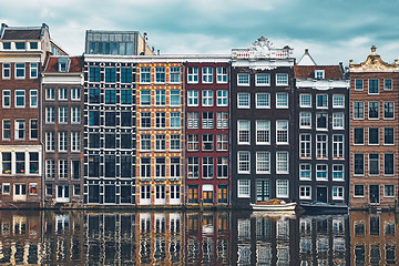 Image showing houses and boat on Amsterdam canal Damrak with reflection. Ams