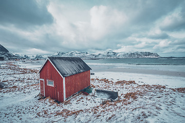 Image showing Red rorbu house shed on beach of fjord, Norway