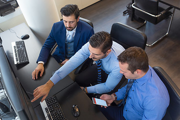 Image showing Business team analyzing trade data on computer in corporate trading office.