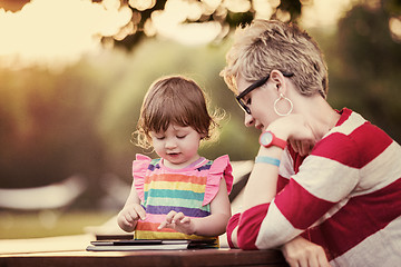 Image showing mom and her little daughter using tablet computer