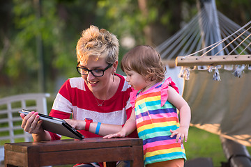 Image showing mom and her little daughter using tablet computer