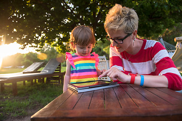 Image showing mom and her little daughter using tablet computer