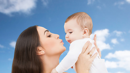 Image showing mother kissing baby over sky background