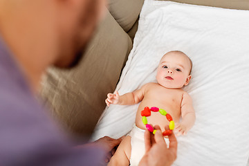 Image showing close up of father and baby with rattle toy