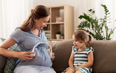 Image showing pregnant mother and little girl with headphones