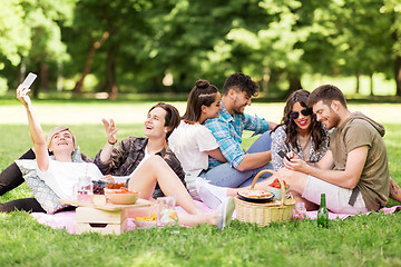 Image showing friends with smartphones on picnic at summer park