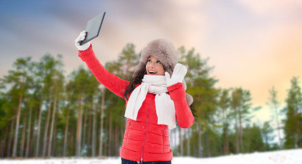 Image showing woman in winter fur hat with tablet pc outdoors