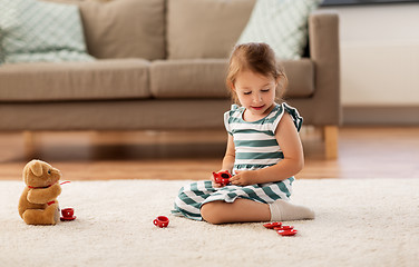 Image showing little girl playing with toy tea set at home