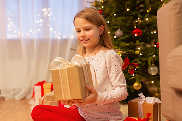 Image showing smiling girl with christmas gift at home