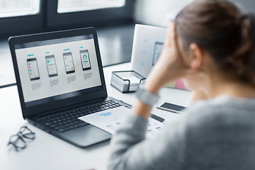 Image showing stressed designer with user interface on laptop