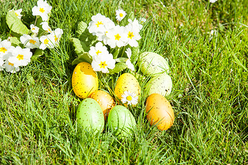 Image showing colored Easter eggs hidden in flowers and grass