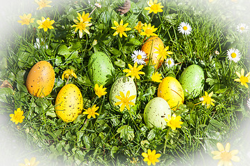 Image showing colored Easter eggs hidden in flowers and grass