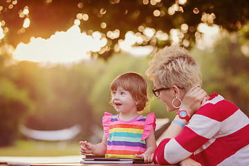 Image showing mom and her little daughter using tablet computer