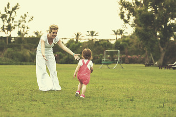 Image showing mother and little daughter playing at backyard