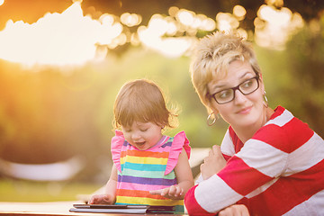 Image showing mom and her little daughter using tablet computer