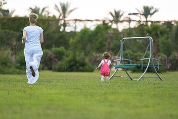 Image showing mother and little daughter playing at backyard