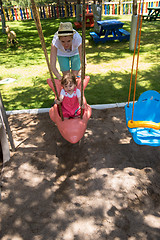 Image showing mother and daughter swinging in the park