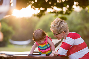 Image showing mom and her little daughter using tablet computer