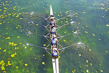 Image showing Four Womens rowing team on blue lake, Aerial view