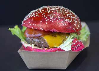 Image showing Red burger sprinkled with sesame seeds on a street market