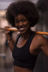 Image showing black woman lifting empty bar