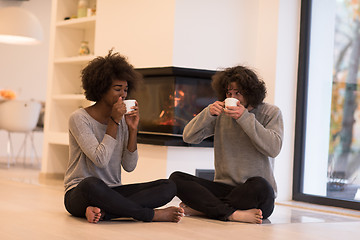 Image showing multiethnic couple  in front of fireplace