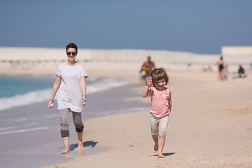 Image showing mother and daughter running on the beach