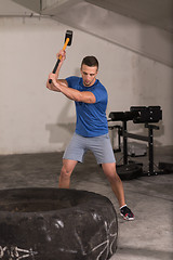 Image showing man workout with hammer and tractor tire