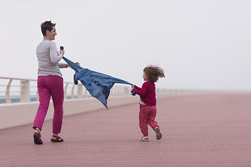 Image showing mother and cute little girl on the promenade by the sea