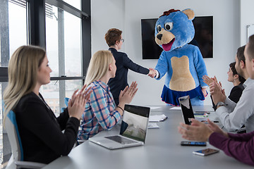 Image showing boss dresed as bear having fun with business people in trendy of