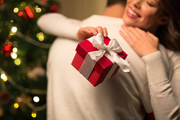 Image showing close up of couple with christmas gift hugging