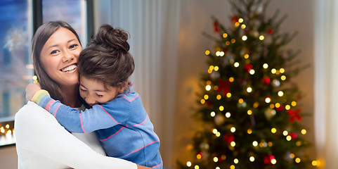 Image showing happy mother hugging her daughter on christmas