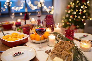 Image showing glass of red wine and food on christmas table