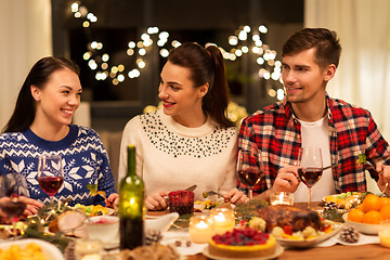 Image showing happy friends having christmas dinner at home