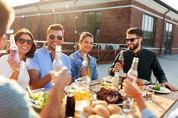 Image showing happy friends with drinks or bbq party on rooftop