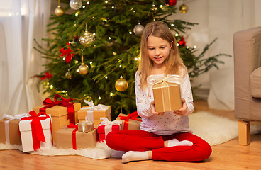 Image showing smiling girl with christmas gift at home