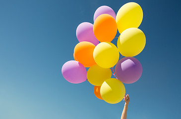 Image showing close up of colorful helium balloons in blue sky