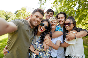 Image showing happy friends taking selfie outdoors in summer