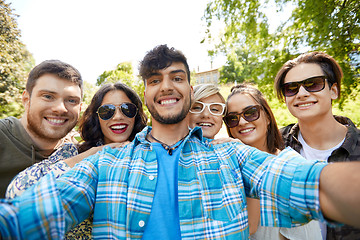 Image showing happy smiling friends taking selfie at summer park