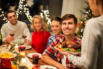 Image showing happy friends having christmas dinner at home