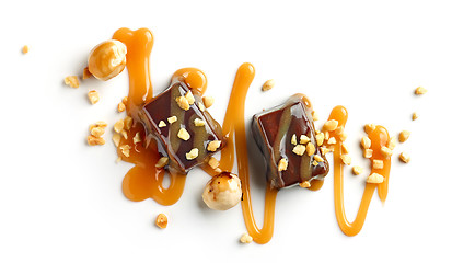 Image showing chocolate candies decorated with caramel sauce and nuts