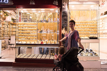 Image showing mother with  little girl in a stroller in front of  jewelry shop