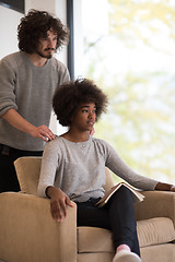 Image showing multiethnic couple hugging in front of fireplace