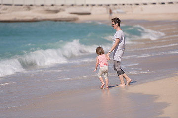 Image showing mother and daughter running on the beach